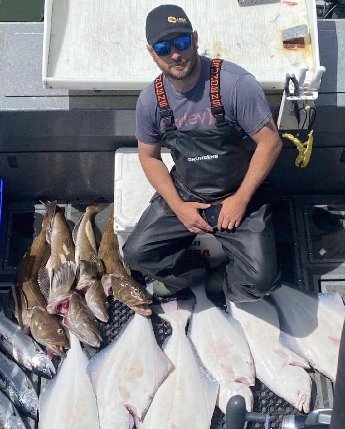 Man sitting on a boat ling cod and halibut